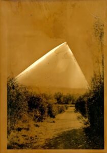 un chemin dans un jardin et une montagne au fond, réalisé en tirage argentique.